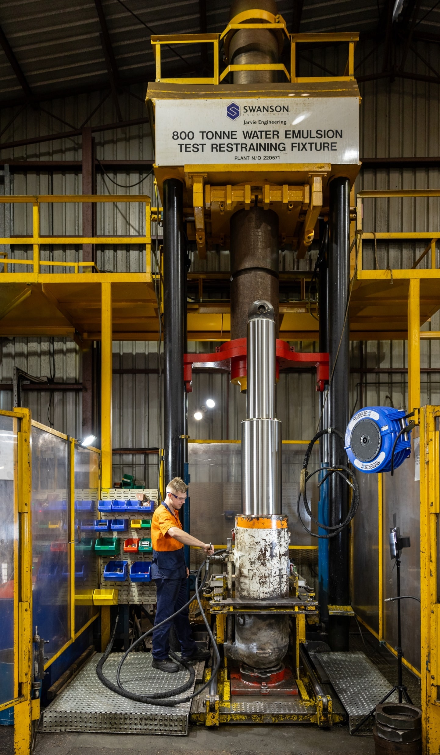 a man working on a 800 tonne test restraining fixture for a hydraulic cylinder