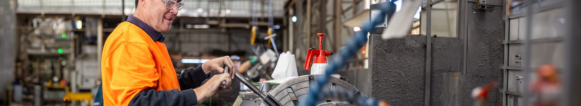 A person working on a hydraulic cylinder manufacturing station